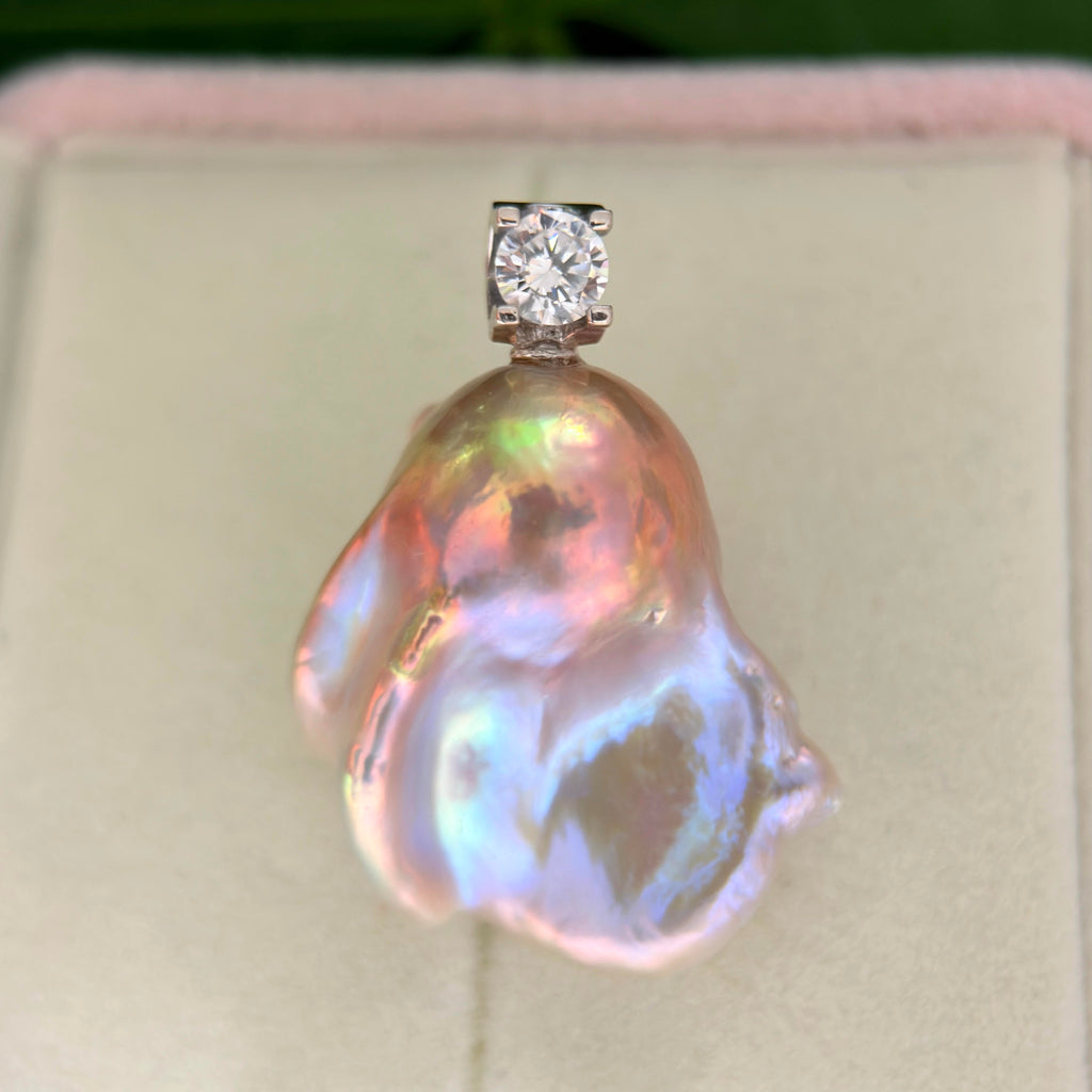 Detailed product view of whimsical blue baroque freshwater pearl pendant with colorful iridescent halo and silver setting.