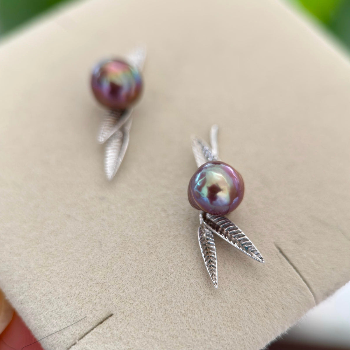 Artistic baroque pearl earrings with detailed bamboo leaf accents.
8 mm purple pearl earrings with an organic sculptural look.
