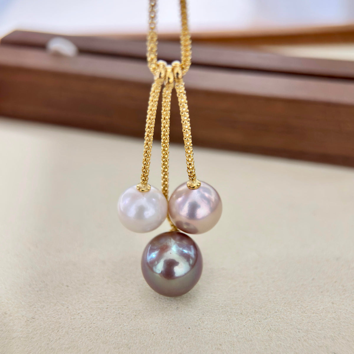 Three-pearl necklace featuring purple, pink and white freshwater pearls.