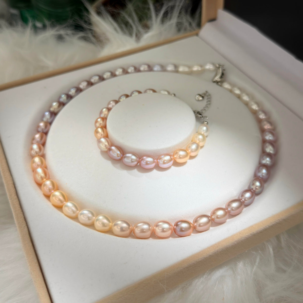 Multicolor pearl necklace transitioning from purple to champagne and peach tones.
