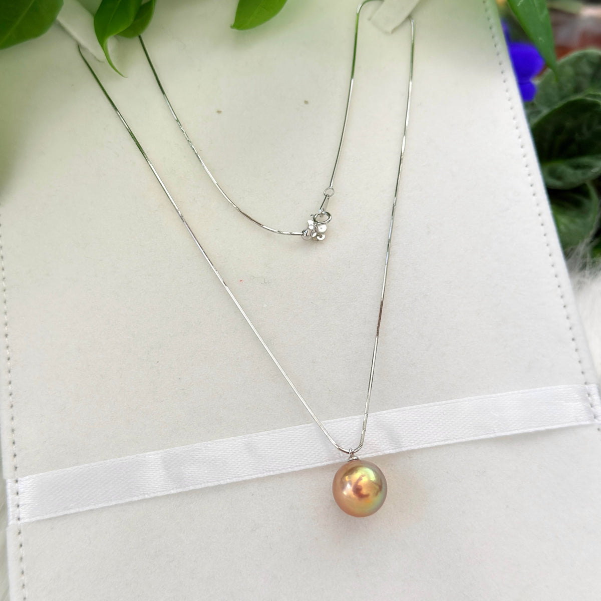 Large freshwater pearl displaying vivid shifting iridescent colours.