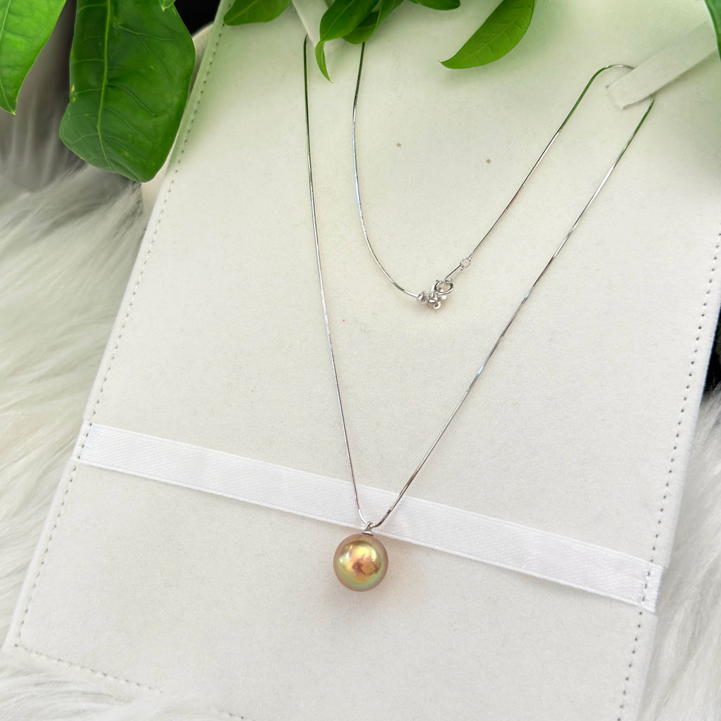 Minimalist single-pearl necklace styled for day-to-night wear.