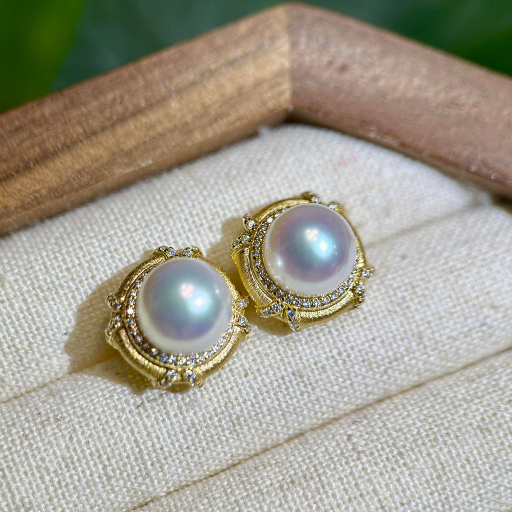 White pearl earrings with soft pink and blue iridescent overtones.