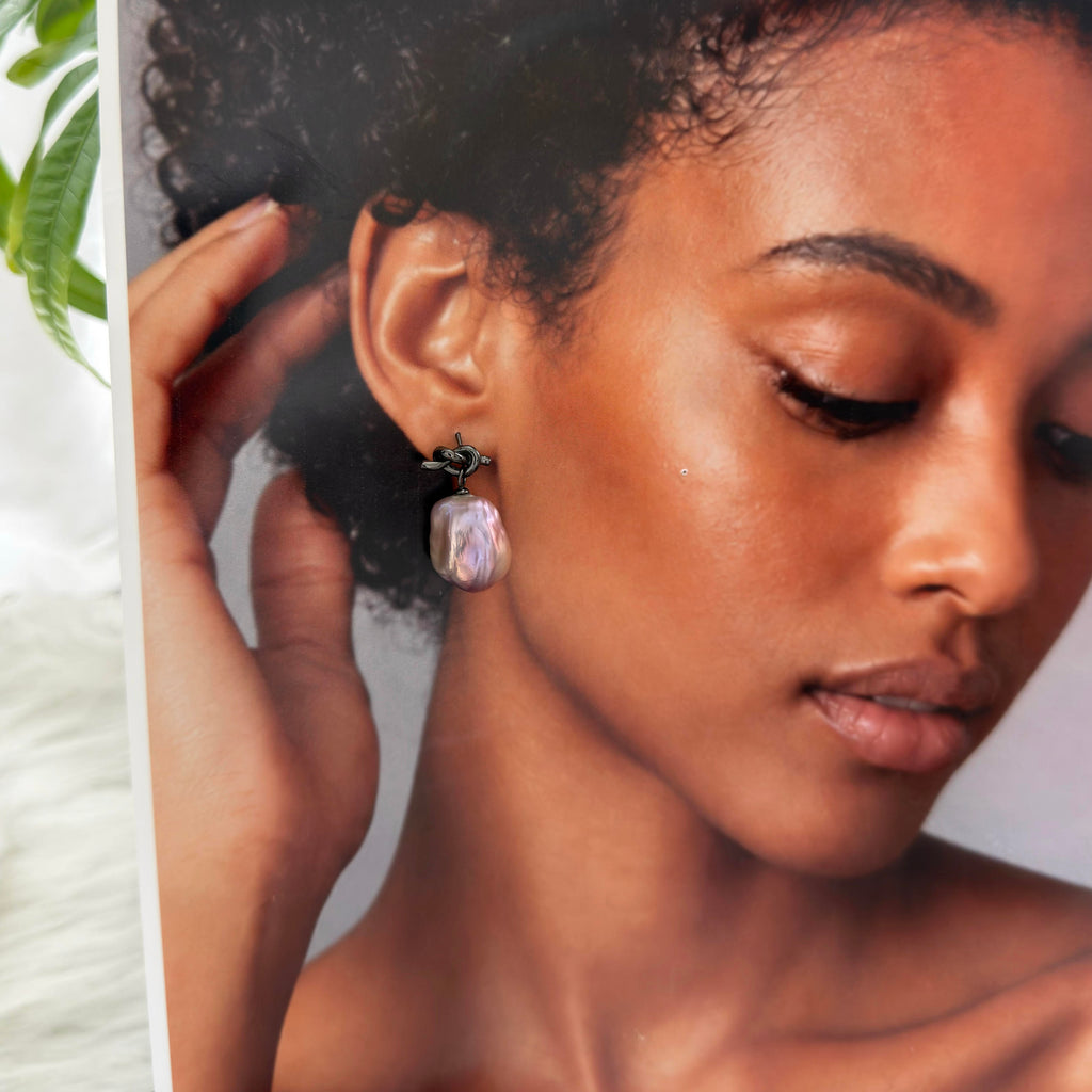 
Model wearing baroque freshwater pearl drop earrings.
Model wearing large multicolor pearl earrings.