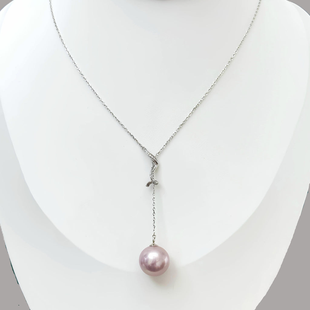 A silver Y-shaped pendant necklace with a single dangling pink pearl, displayed on a white jewelry bust.