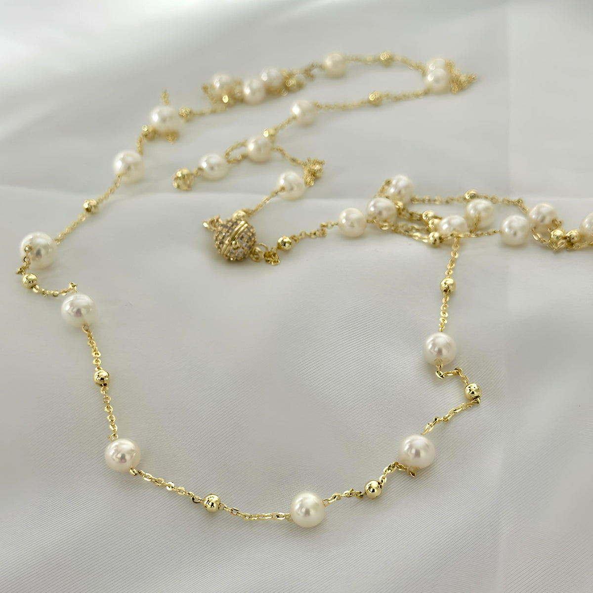 Spaced freshwater pearls arranged along a fine gold-tone necklace chain