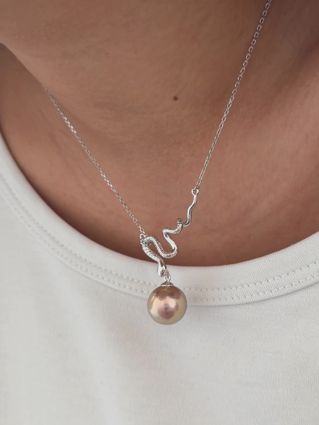 Sterling silver snake pendant suspending a large natural freshwater pearl.