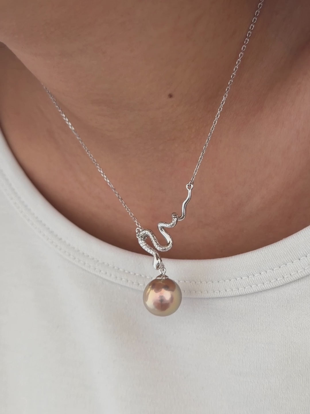 Sterling silver snake pendant suspending a large natural freshwater pearl.
