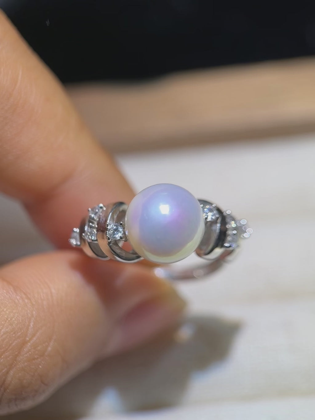 Freshwater pearl ring displaying blue and pink iridescence.
