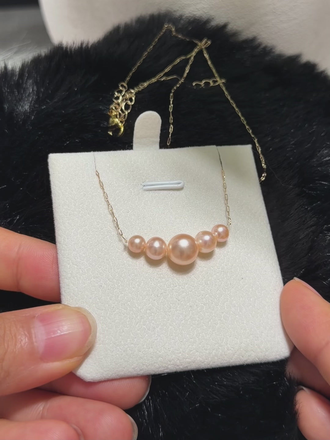 Smile-curve pearl necklace with modern feminine styling.
