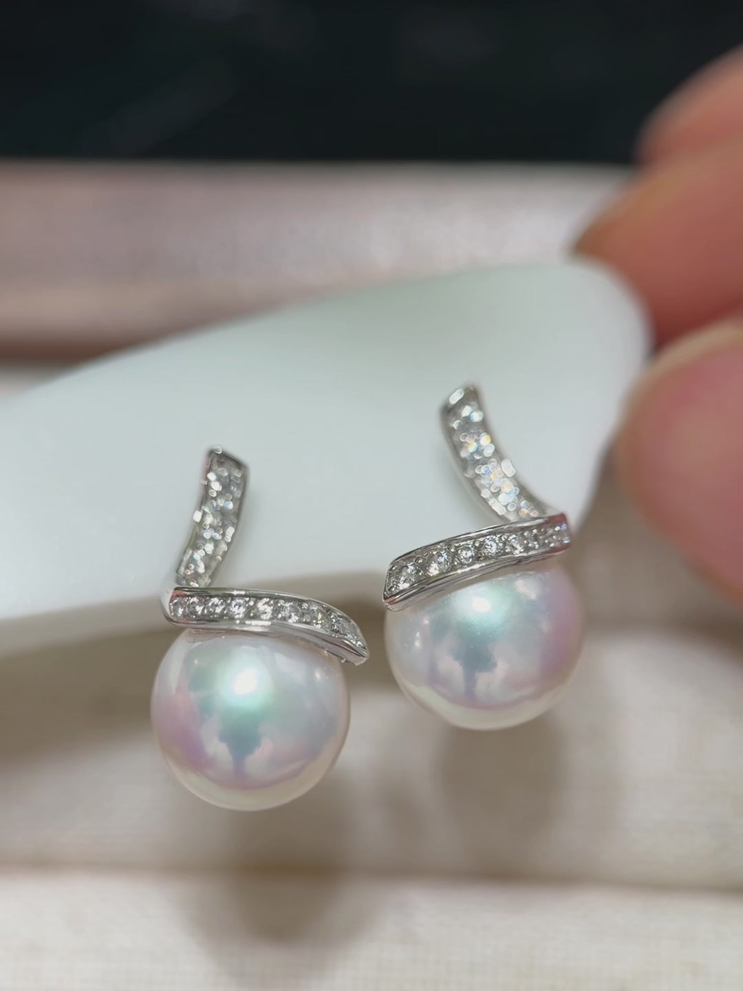Mirror-luster freshwater pearl earrings displaying blue and pink iridescent halos.