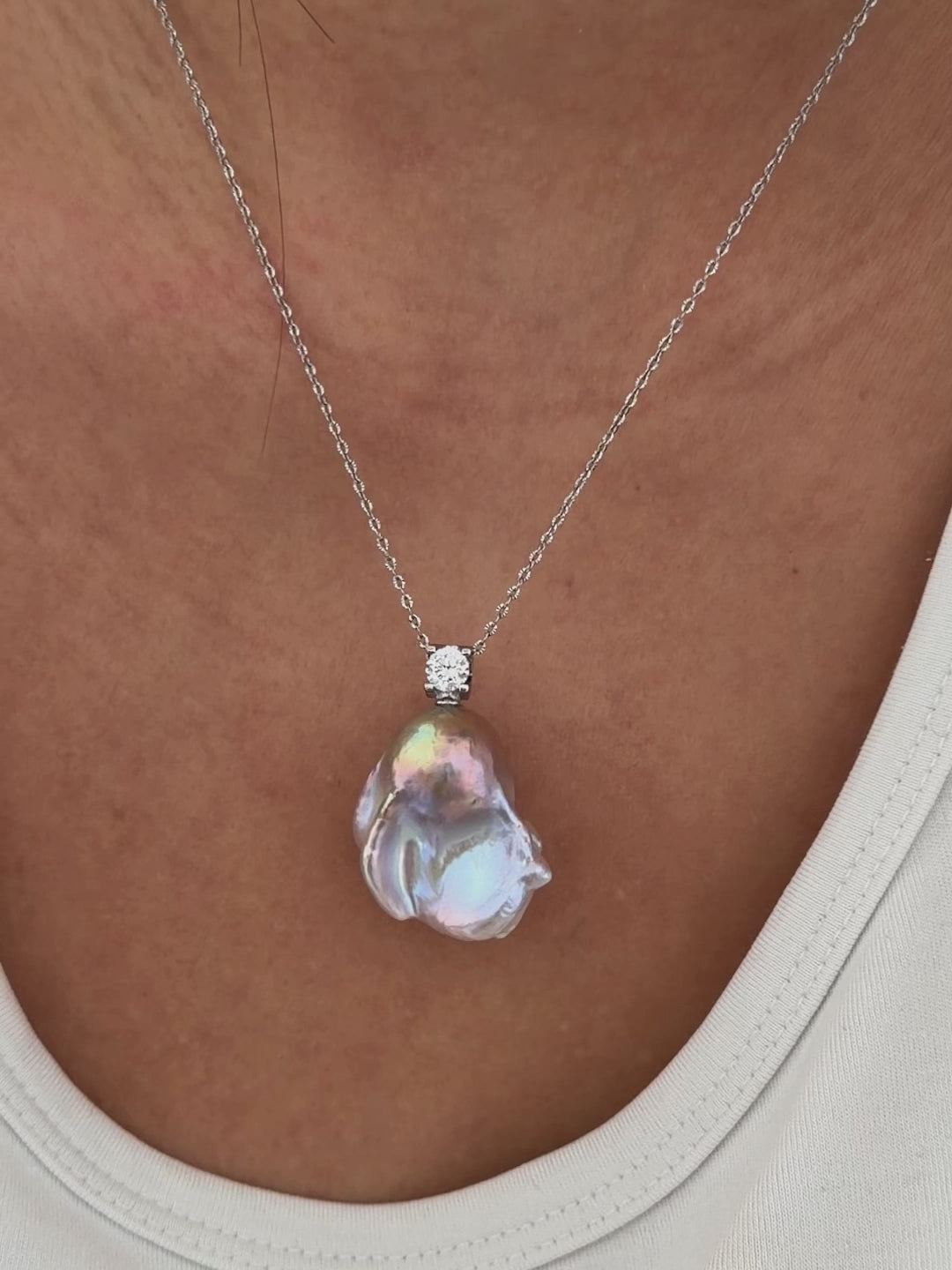 Unique pearl form shown in whimsical blue baroque freshwater pearl pendant with colorful iridescent halo and silver setting.