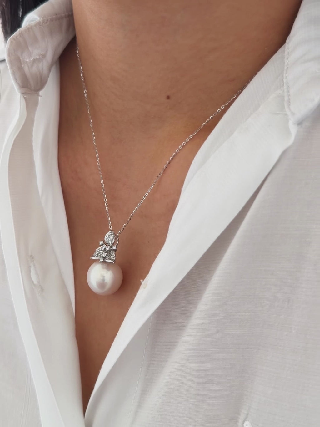 Oversized white pearl necklace with modern feminine styling.
15 mm pink-halo pearl pendant styled as bridal or evening jewelry.
