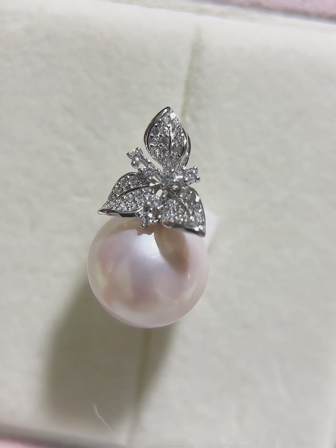 Romantic pearl pendant featuring a sparkling floral setting.