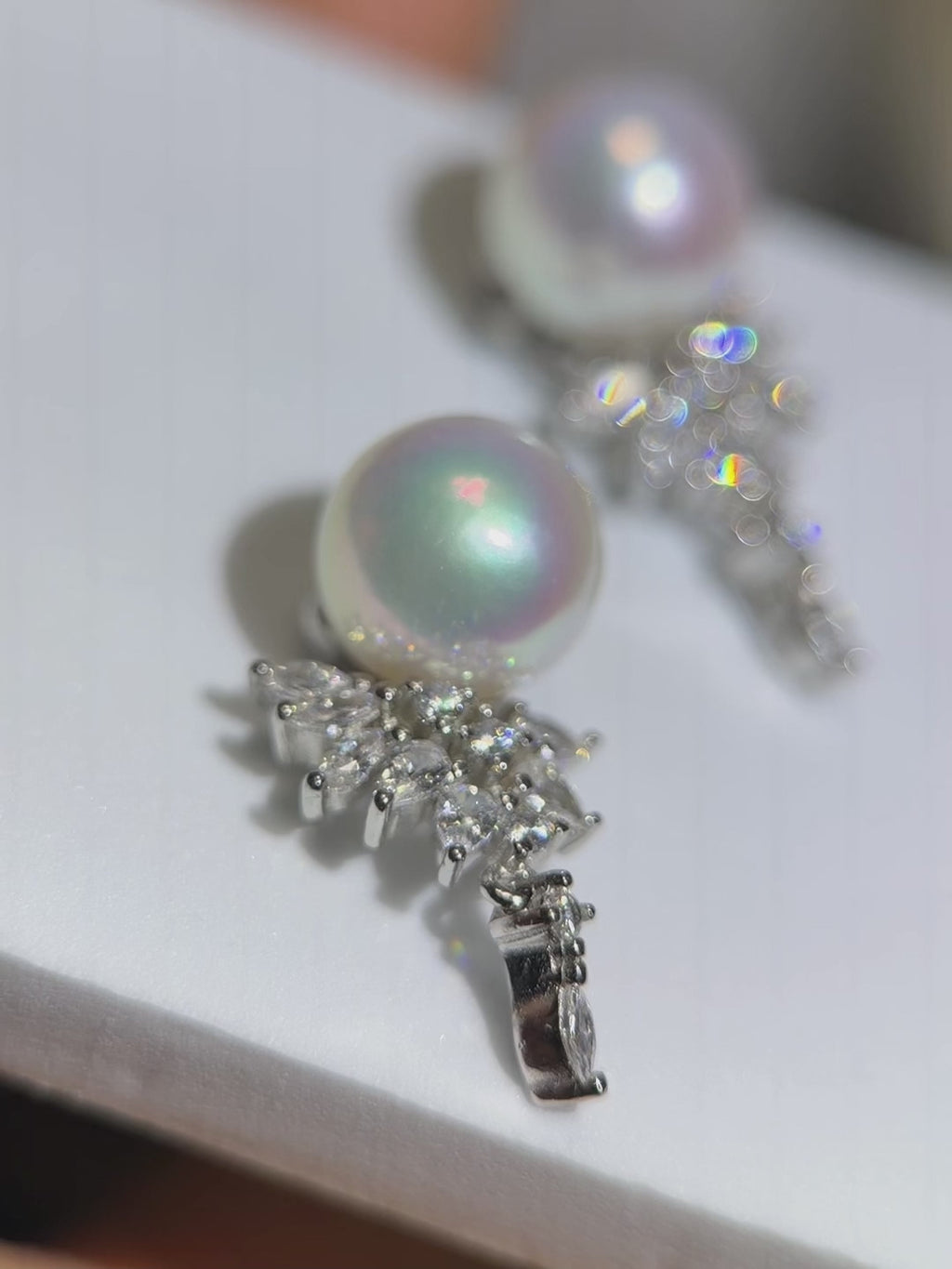 Mirror-shine pearl drop earrings crafted in 925 sterling silver.Blue and pink halo pearl earrings designed as elegant jewelry.