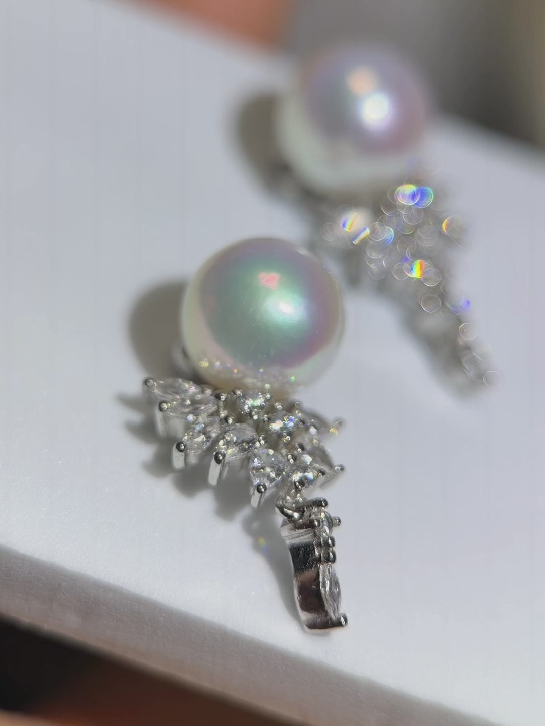 Mirror-shine pearl drop earrings crafted in 925 sterling silver.Blue and pink halo pearl earrings designed as elegant jewelry.