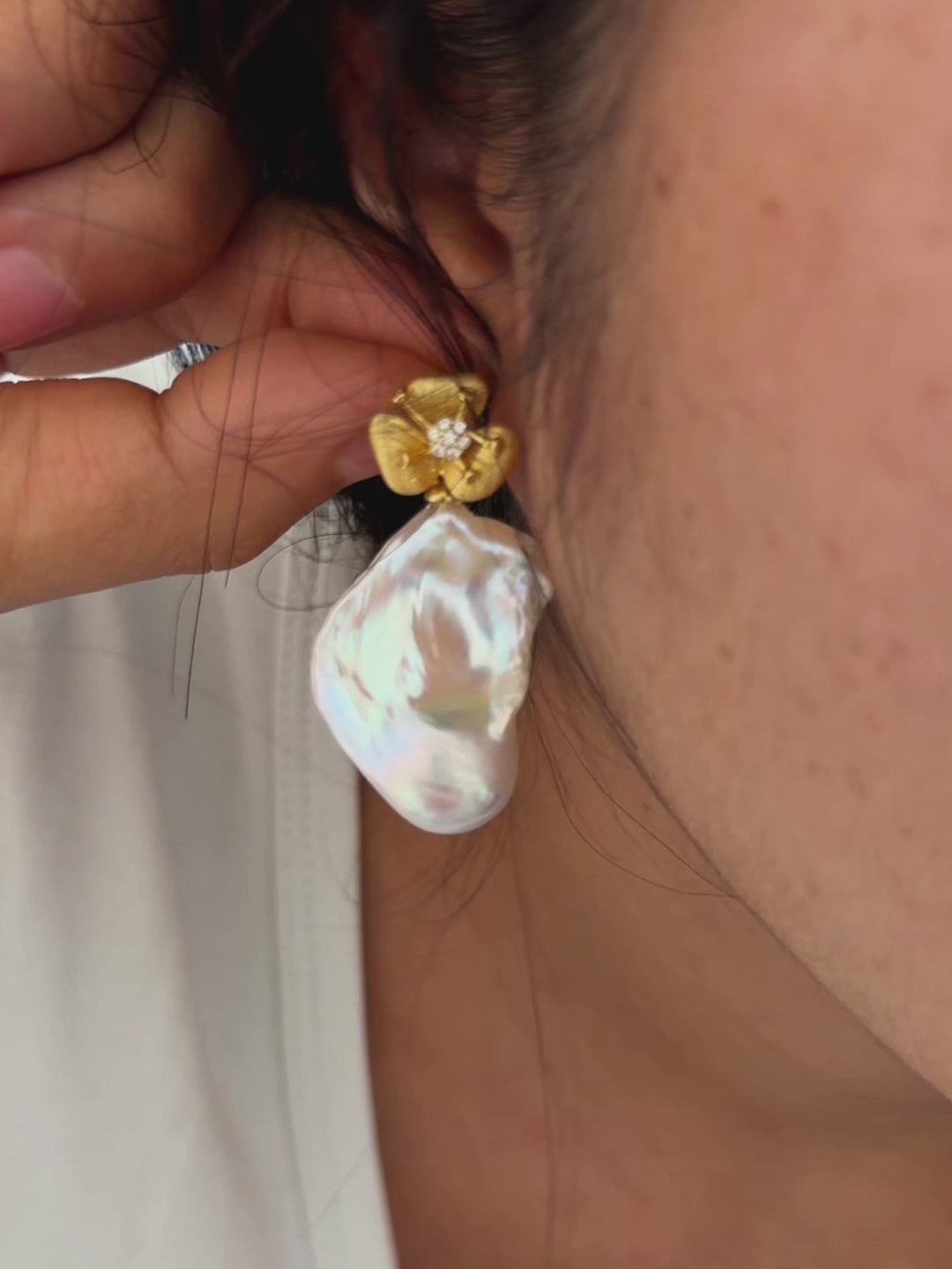 Model wearing convertible pearl earrings with detachable drops.