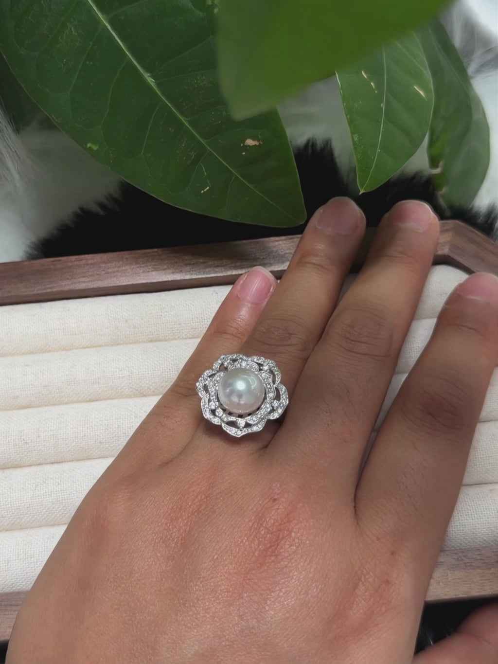 Mirror-luster freshwater pearl framed by a detailed floral silver setting.