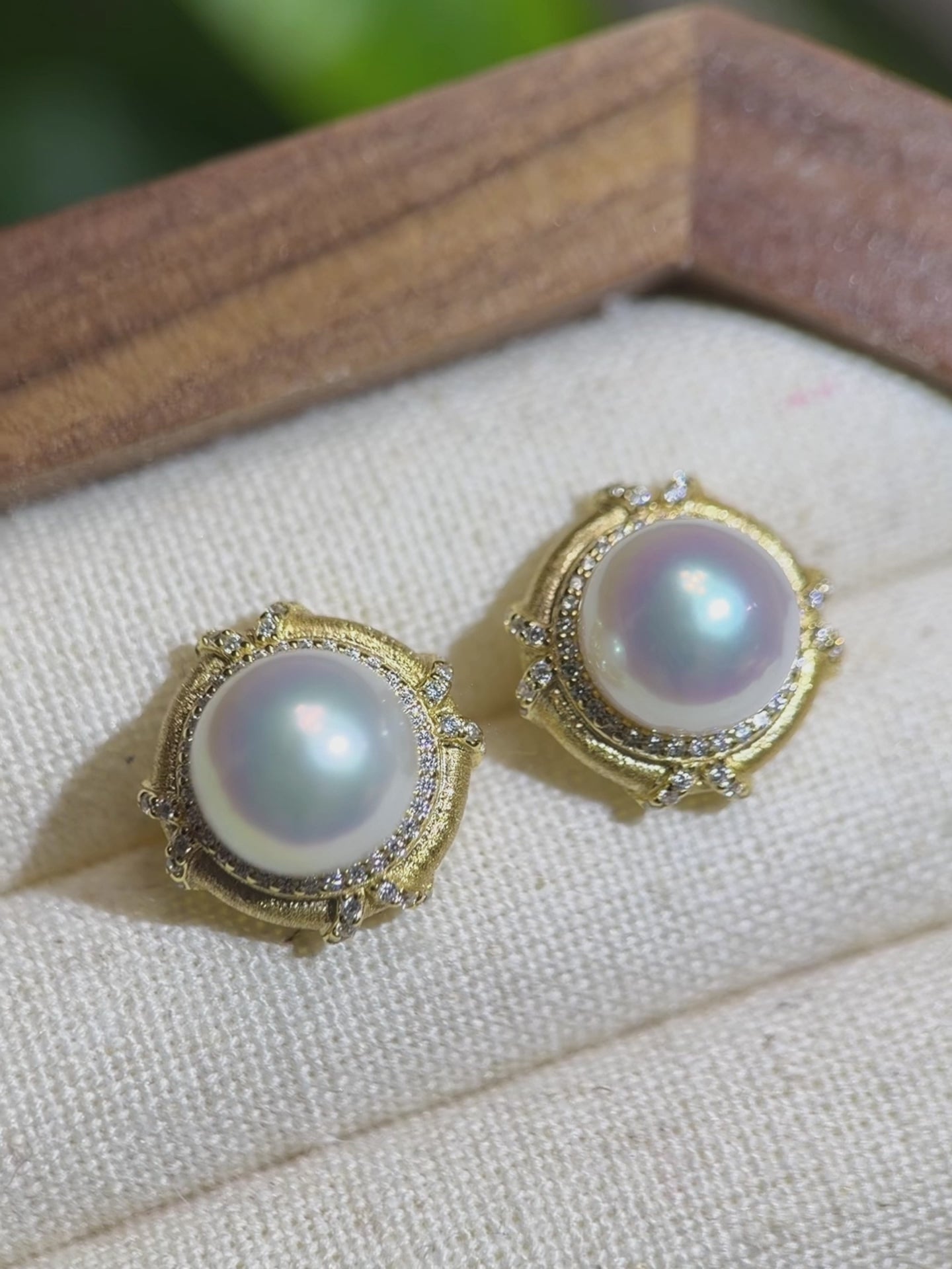 Mirror-shine freshwater pearl earrings showing pink and blue reflections.