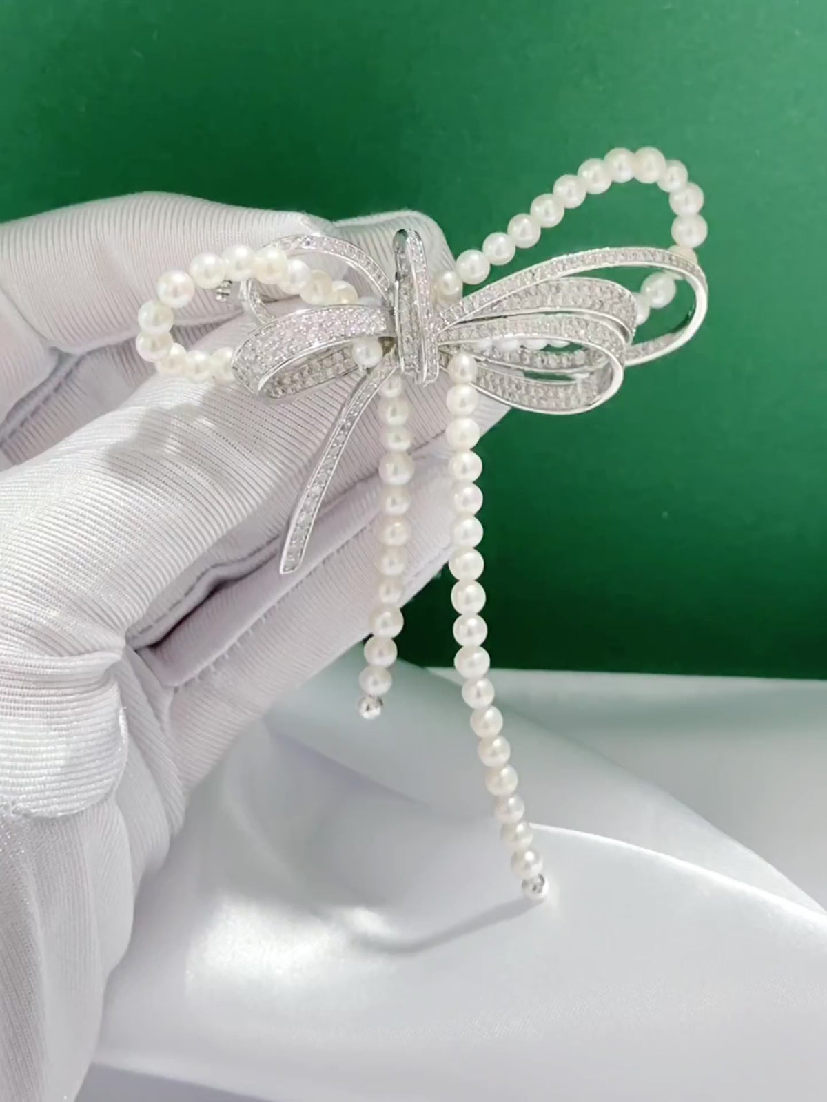 Bow brooch featuring luminous 4 mm white freshwater pearls and elegant curved detailing.