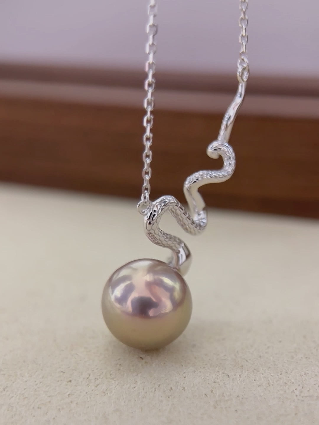 Iridescent freshwater pearl displaying brown, green and red colour shifts.