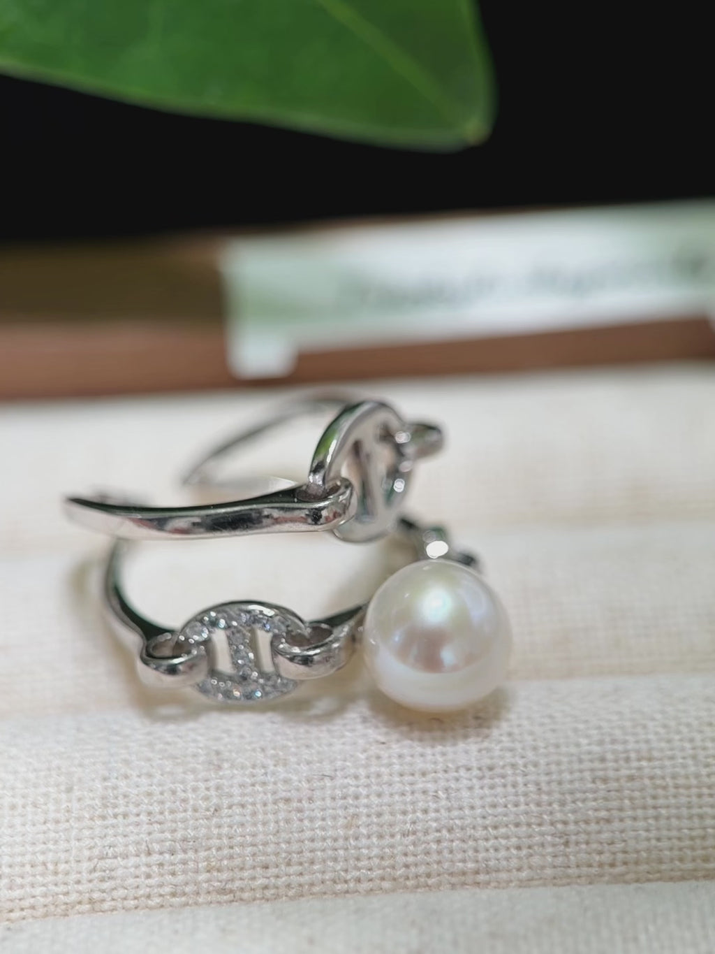 Contemporary pearl statement ring with architectural silver setting.
