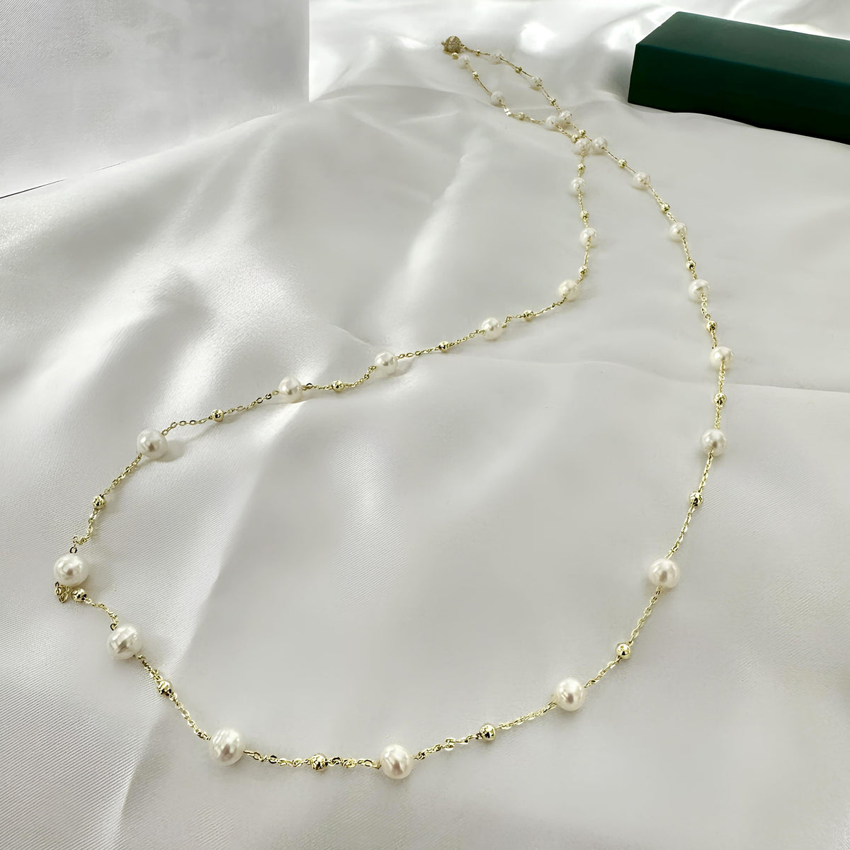 Long white pearl necklace presented as an elegant gift for her.
